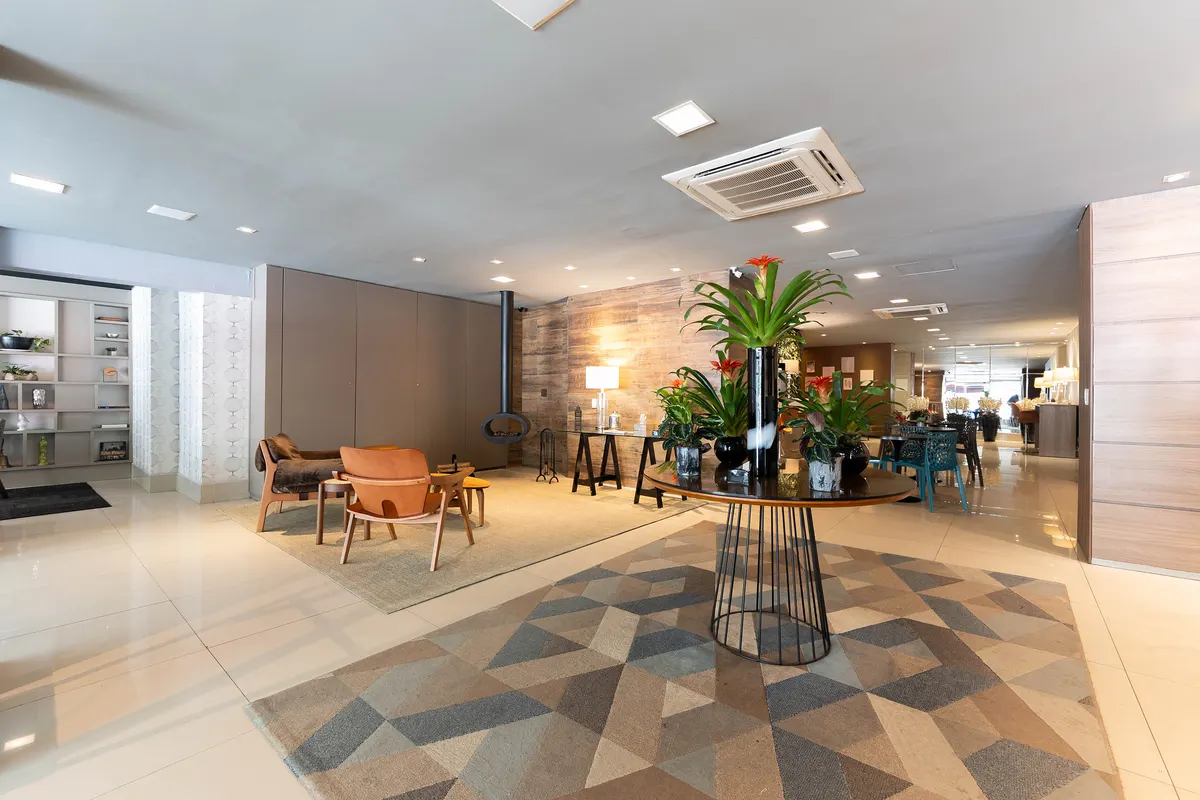 Lobby do Hotel Heritage com orquídeas, poltronas e lareira ao fundo